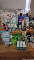 Overview photo showing a large collection of personal care items including shampoo, lotion, soap bars, and a decorative floral metal tray.