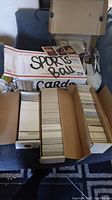 Five cardboard boxes filled with sports trading cards including some USPS Priority Mail boxes with handwritten 'SPORTS BALL CARDS'.