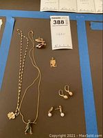 Six jewelry pieces arranged around lot tag 388 on black background