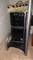 Front and partial side view of black HP Pavilion P7-1520t desktop tower showing multimedia optical drive, Beats Audio logo, memory card reader and USB drive attached