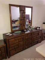 Front view of brown wood dresser with mirror and decorative block design
