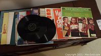 Photo of assorted vinyl albums laid out, showing album covers including Nat King Cole and others