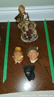 All five items including three Bossons wall heads and two figurines shown on floor within green tape markers
