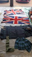 Overview of two Union Jack flags laid flat with two kilts, sock, and sporran