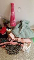 Full lot including folded pink and white parasol, green crinoline dress with pink skirt, various accessories including gloves, black beaded handbag, and a bag of other small items