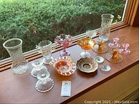 Full lot showing various clear glass and colored glassware including vases, candle holders, bowls, and decorative pieces.