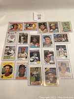 Group photo of vintage baseball cards laid out on white background showing various players from 1950-1970s era.