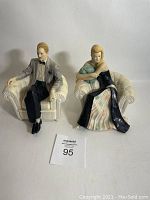 Pair of Charles and Anna 1987 signed ceramic statues by Vittorio Tessaro. Both seated on white tufted armchairs.