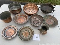 Antique Turkish copperware collection with 10 items displayed on white table outdoors.