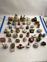 Wide shot of entire collection showing all porcelain trinket boxes arranged on white backdrop