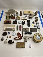 Full overview of all assorted small collectibles including watches, figurines, model car, and boxes, laid flat on a white surface.