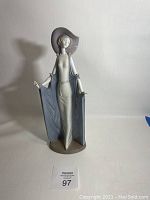 Front view of Lladro porcelain figurine showing full figure in dress and hat.