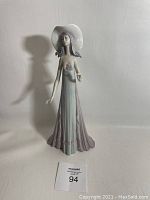 Front-full view of Lladro porcelain figurine depicting woman in flowing dress and hat, standing.