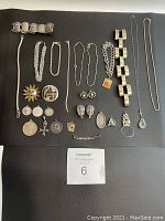 Assorted sterling silver jewelry arranged on black surface to show full lot