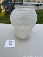 Front view of the frosted glass Nubian female head vase showing facial features and textured hair.