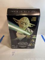 Front view of the sealed box featuring Yoda with a green lightsaber and text 'Train to be a Jedi' and 'Yoda comes to life!'