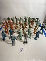 Photo showing the full assortment of vintage plastic figures in green, brown, blue, and gray, arranged in rows highlighting variety of characters.