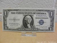 Front full view of the 1935 silver certificate one dollar bill showing the complete bill including the portrait of George Washington, serial number and denomination.