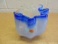 Front view of a blue and clear art glass vase with a ruffled, irregular shape and Norleans Japan label.