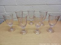 Front view of all 7 pink glasses showing their swirl patterns and shape.
