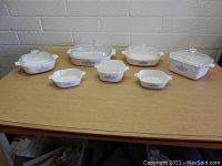 Full view of seven Corning Ware Blue Cornflower dishes on table, front-facing.