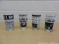 Four glasses in a row with black and white printed newspaper front page headlines from the Arizona Republic.