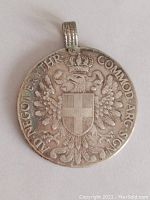 Close-up of antique Italian Eritrea thaler coin front side with soldered silver loop attached for use as pendant.