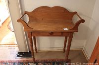 Full front view of the antique wood washstand table, showing the drawer and side rails