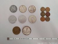 Full overview showing all coins including 50 cent pieces, dollar coins, medallion and pennies with measuring tape for scale.