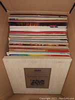 Box of vinyl records with visible album cover of Johann Sebastian Bach Weihnachts-Oratorium, showing worn cardboard sleeves and vintage album art.