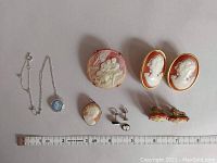 All jewelry items arranged with measuring tape showing lengths and sizes for scale.