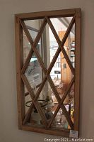 Front view of rectangular wooden framed mirror with a lattice design creating diamond shapes