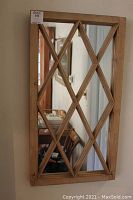 Front view of rectangular wood framed mirror with diamond lattice detail.