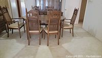 Photo showing nine pieces: rectangular wooden dining table with chairs around it in living area