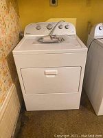 White Whirlpool electric dryer facing front, showing front door and general condition.