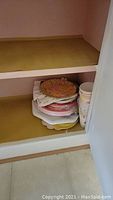Stack of paper plates and cups inside cabinet