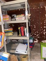 Side view of the white plastic shelving unit filled with books and papers showing shelf design and condition.