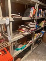 Wide shot of shelving unit filled with assorted books and papers showing condition and structure