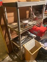 Plastic shelving unit shown from an angle, displaying three slatted shelves and a flat top surface. Some tools and containers on shelves are present but not included in the sale.