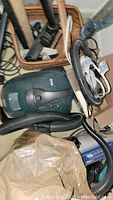 Green Ryno vacuum cleaner with hose and power cord laid out on floor