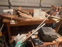 Wooden workbench with various items placed on top and below, showing overall condition and structure.