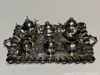 Top view showing all 12 pieces arranged in and around the tray with turquoise-stoned lids.