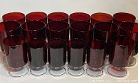 Group photo of 19 ruby red stemmed glasses arranged in rows by size showing color and clarity.