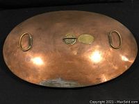 Top view of the copper footwarmer showing two brass handles and central brass components.