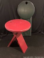 Red stool open in front of folded green stool