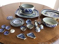Overview of entire lot arranged on table, showing platter, tureens, plates, coasters, bowls, vases and spoon rests