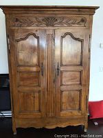 Full front view of cherry wood armoire showing crown molding, dual panel doors and scalloped apron