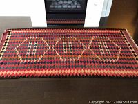 Full view of rug showing overall pattern and fringed ends