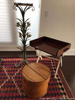 Tall metal plant stand with floral motif, wooden storage box, and foldable stand with removable tray