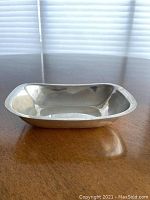 Front angled view of sterling silver bowl on wooden surface